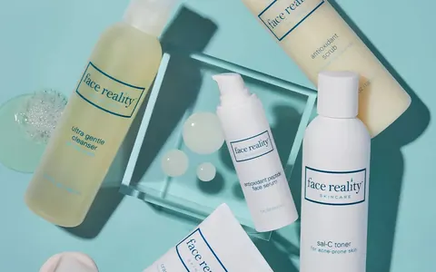Face Reality skincare bottles on a light blue background